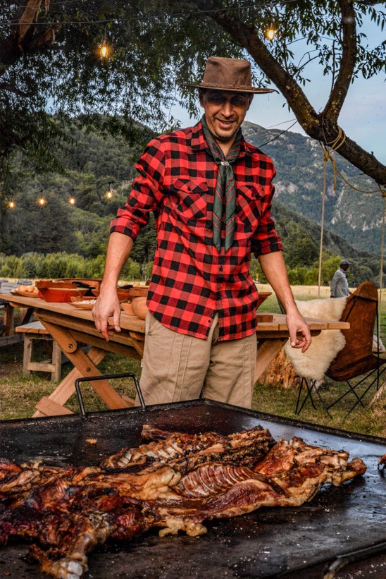 Meat being roasted on a large Asado grill by local Chilean chef.